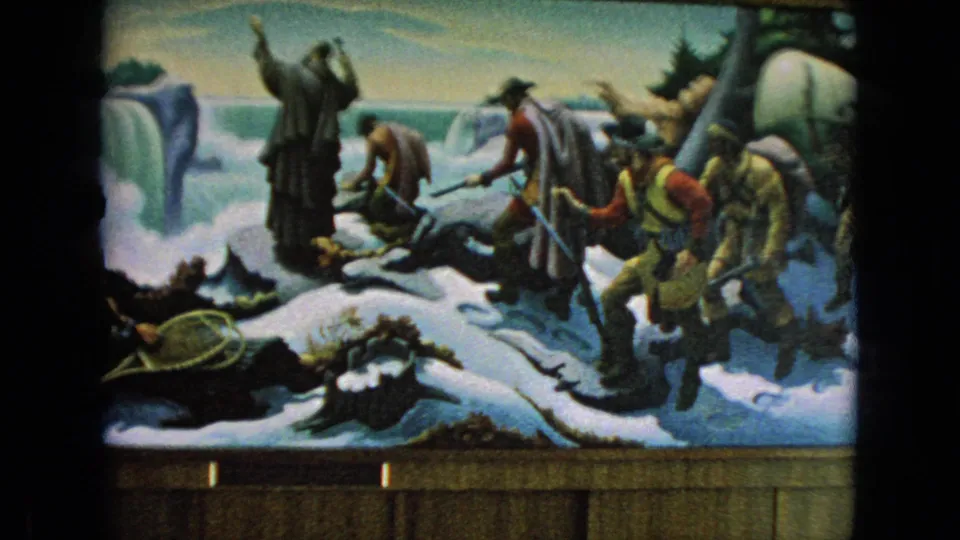 A closer 8mm view of the displayed Niagara Falls mural shows painted figures crossing snow, snowshoes in the foreground, waterfall scenery, and a wooden frame along the bottom.