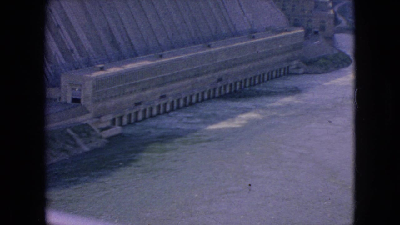 Wide river and dam structure framed by dark film borders.