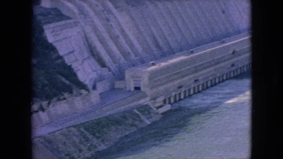 End frame of the 1964 Niagara Falls area home movie, focused on concrete hydro or dam infrastructure along the river with water moving below.