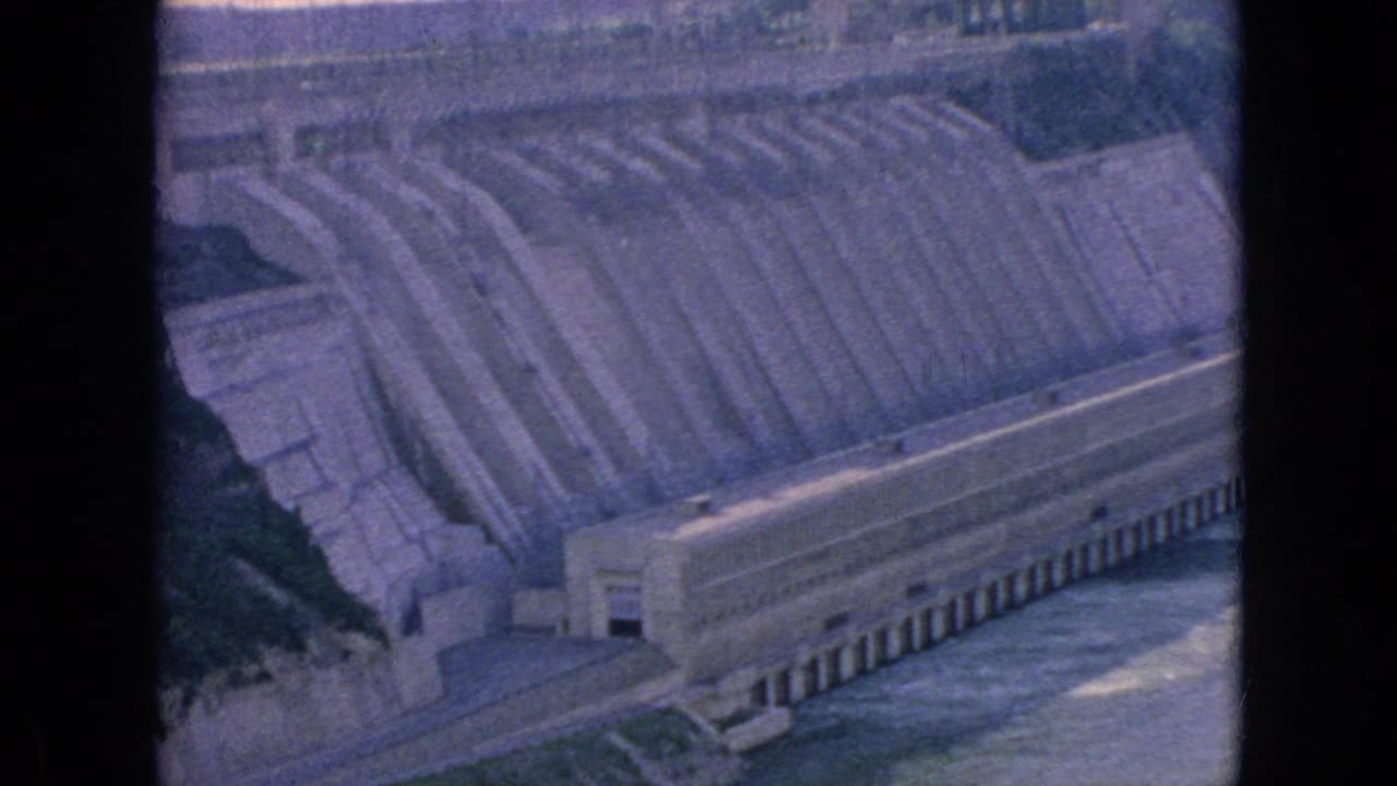 Dam structure and spillway seen through dark 8mm frame borders.