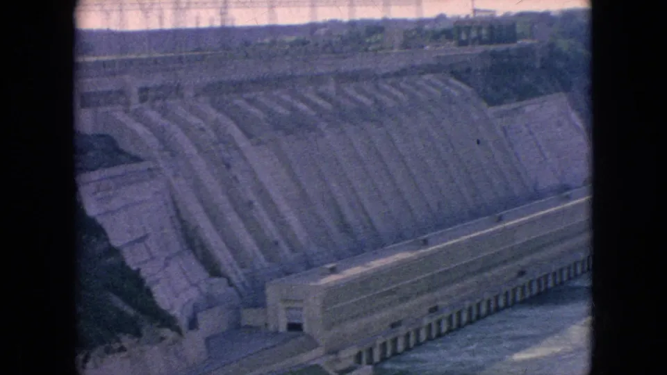 Soft 8mm frame from Niagara Falls, New York, showing the broad stepped concrete spillway and long hydroelectric dam structure with water at the base.