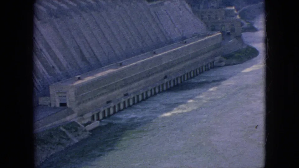 1964 Niagara Falls area frame showing the stepped spillway, long concrete base structure, and active water movement in the river below.