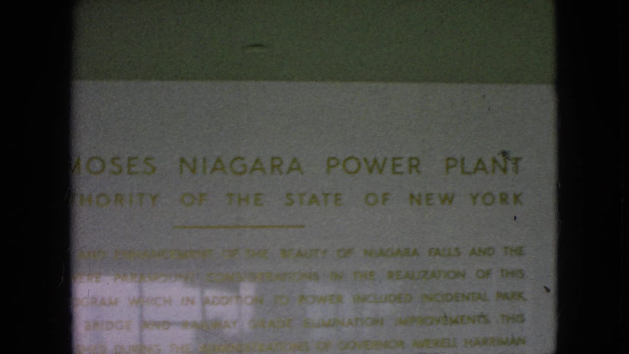 1964 8mm frame showing a close-up of the Moses Niagara Power Plant sign with partially readable Authority of the State of New York text.