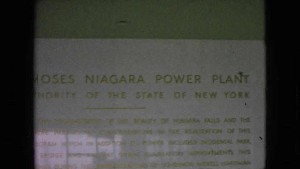 1964 8mm frame showing a close-up of the Moses Niagara Power Plant sign with partially readable Authority of the State of New York text.