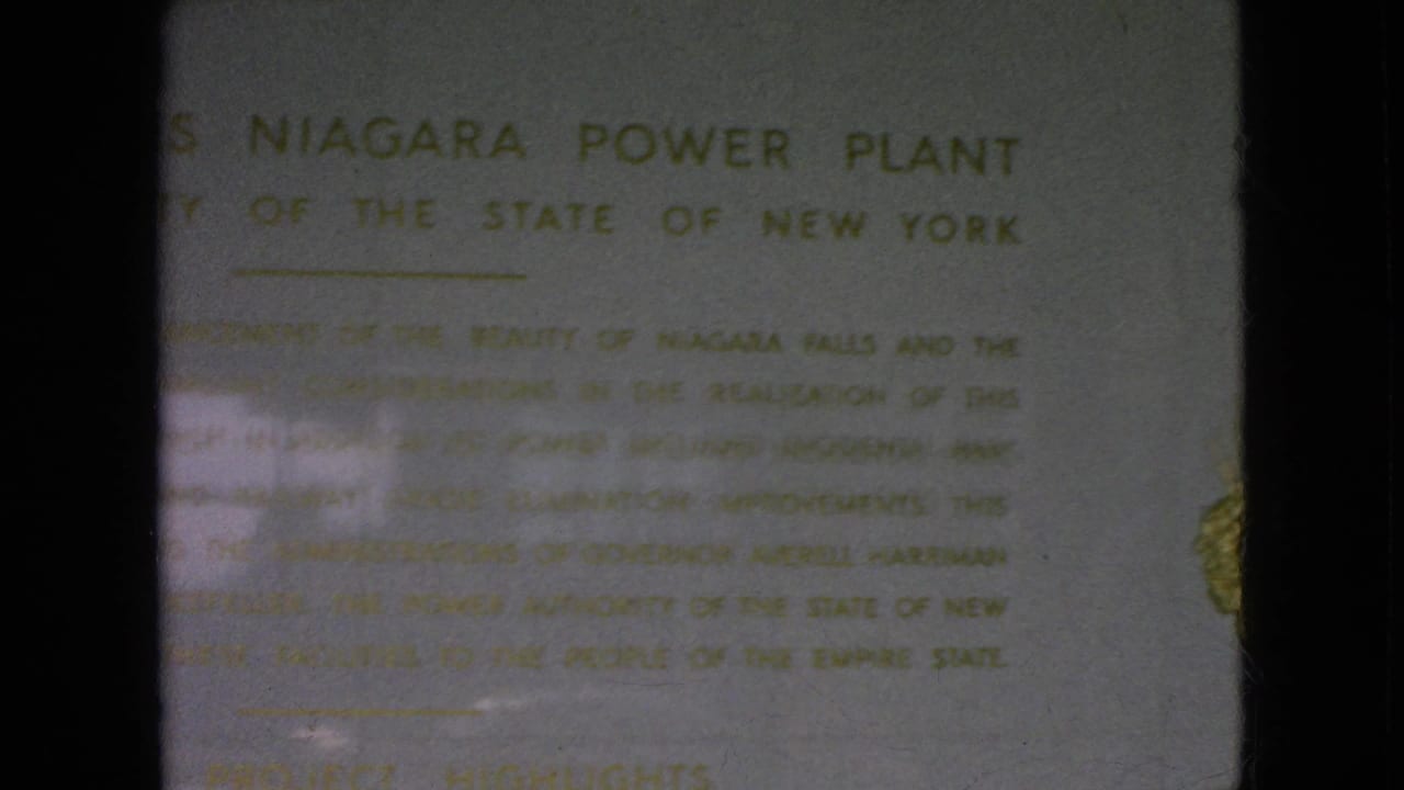Plaque text for the Moses Niagara Power Plant with a gold emblem partly visible at the right edge.