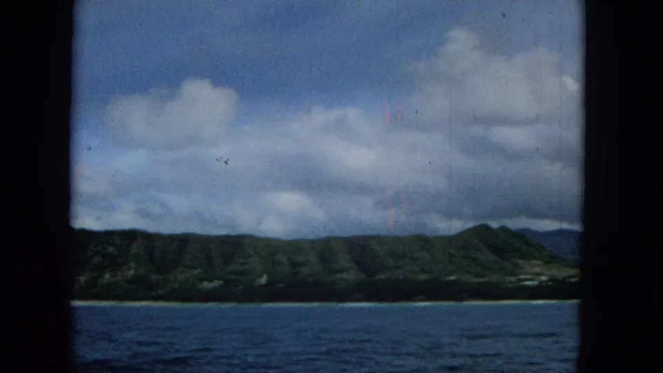 The final frame shows Molokai coastal terrain receding along the waterline, with blue ocean below and layered clouds above.