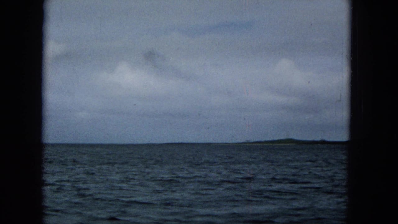 Choppy sea and distant land seen across the horizon under overcast sky.