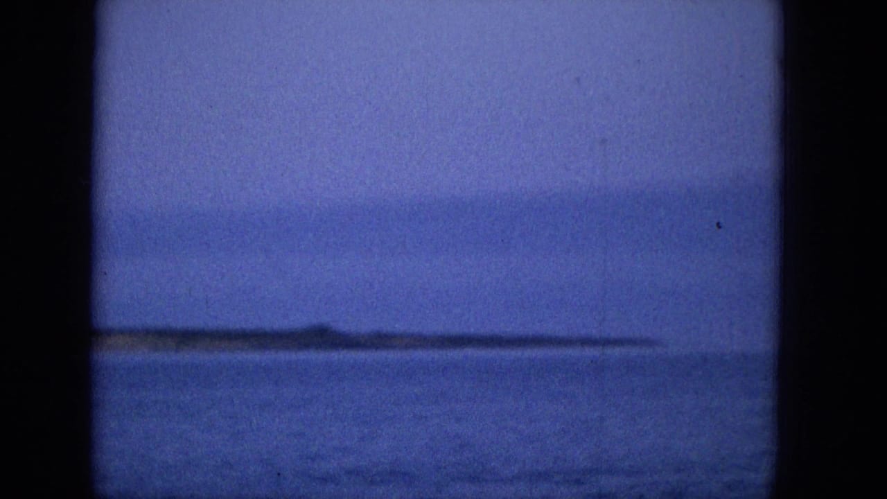 Ocean horizon and distant shoreline seen between dark vertical frame bars.