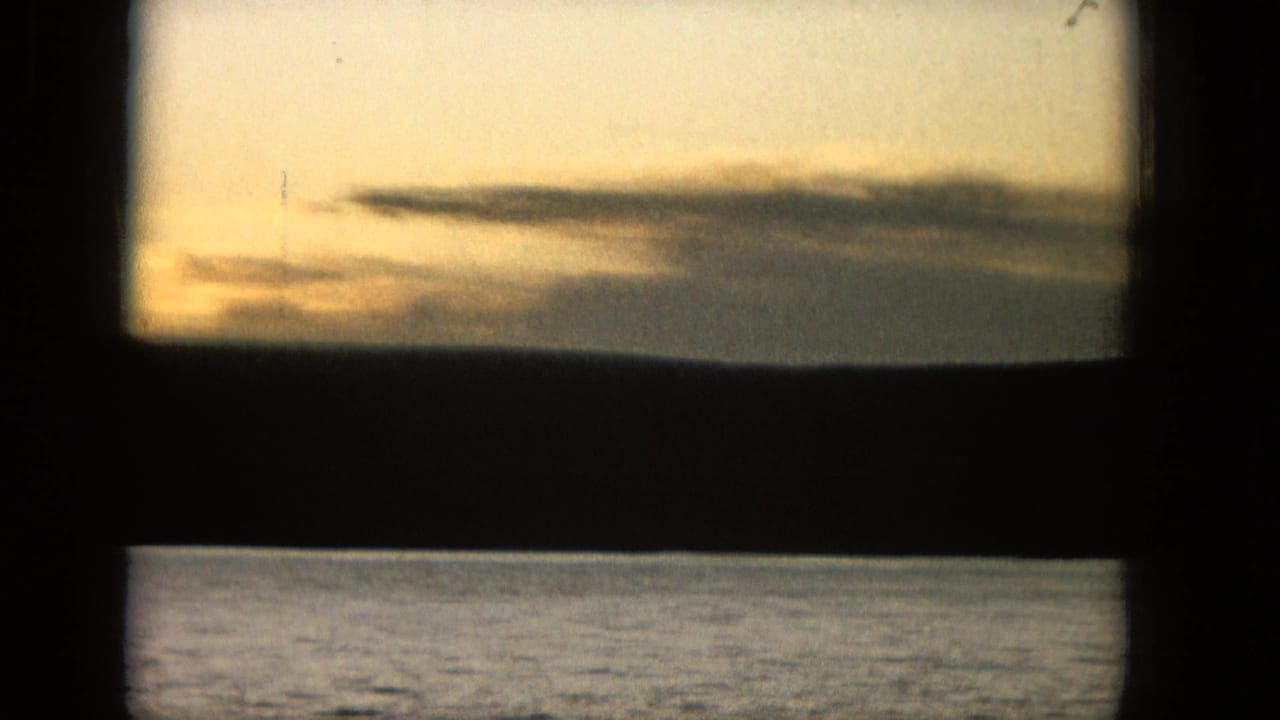 Warm sunset sky and water divided by a dark horizontal frame bar.
