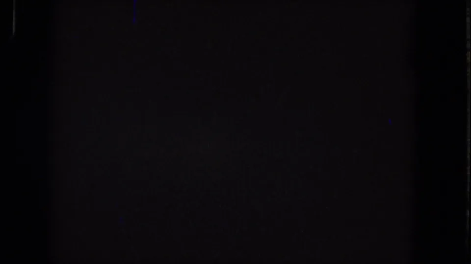 Dark 1965 Super 8 source frame showing near-black exposure, subtle grain, and faint vertical edge marks without identifiable people or place details.