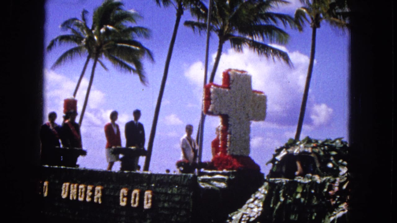 Decorated parade float with floral cross, people standing, palm trees, and "UNITED UNDER GOD" lettering.