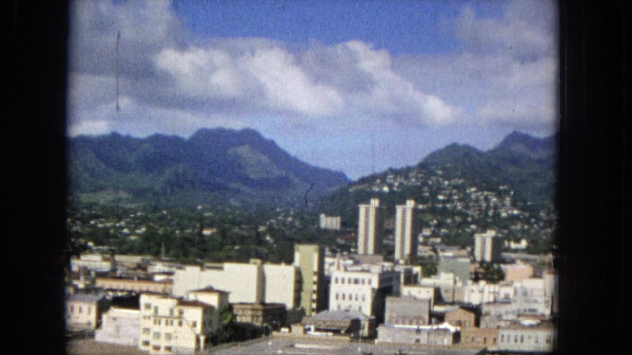 Downtown buildings and twin towers with mountains behind.