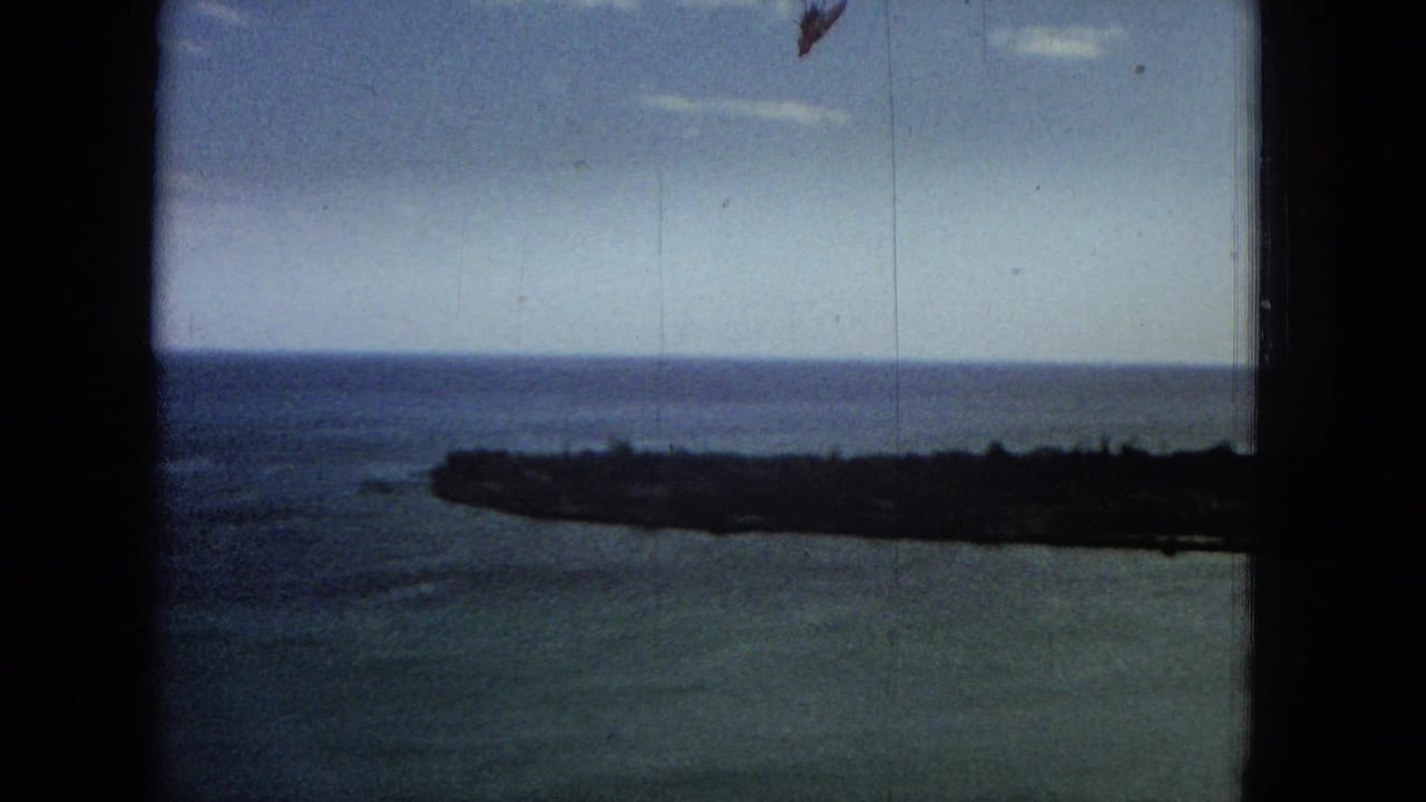 Distant shoreline and open sea beyond a dark vertical frame edge.