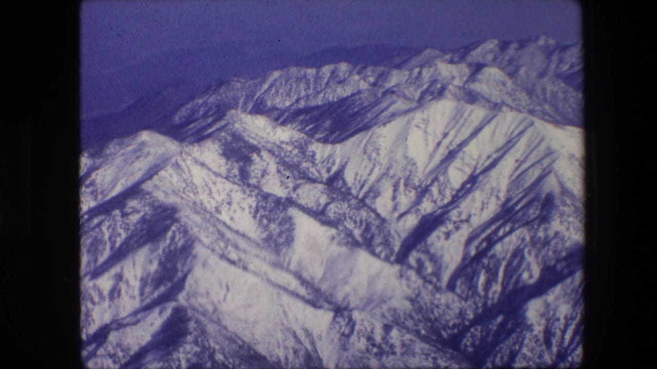 Aerial view of snowy mountain slopes and ridgelines.