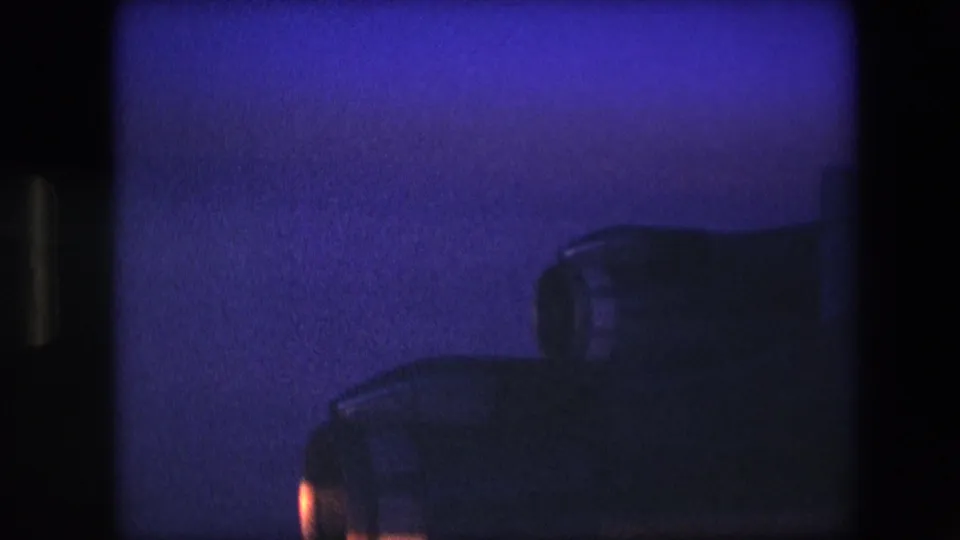 A dark aircraft engine or wing structure appears in silhouette at the bottom of the frame while snowy mountain ridges remain visible above.