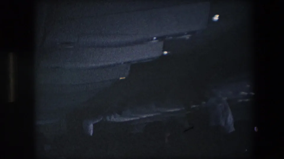 A low-light passenger view shows rows of dark seats and overhead compartments inside the aircraft cabin, with the frame partly obscured by the film contact-sheet border.