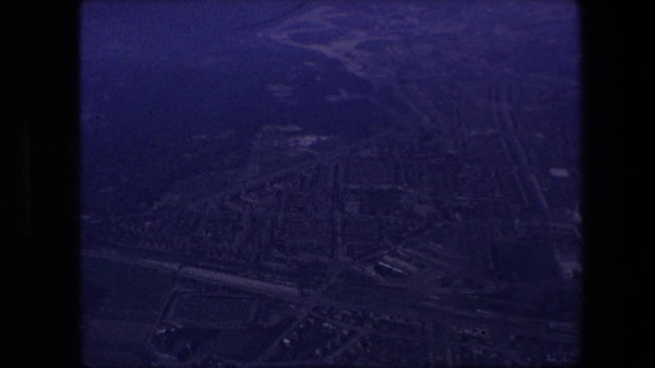 Darker aerial city view seen through the airplane window.