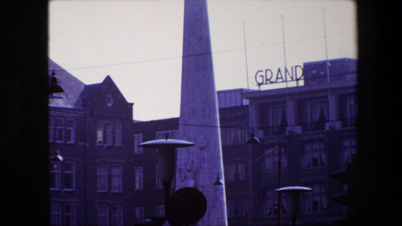 Obelisk in front of brick buildings, with GRAND rooftop lettering visible at right.
