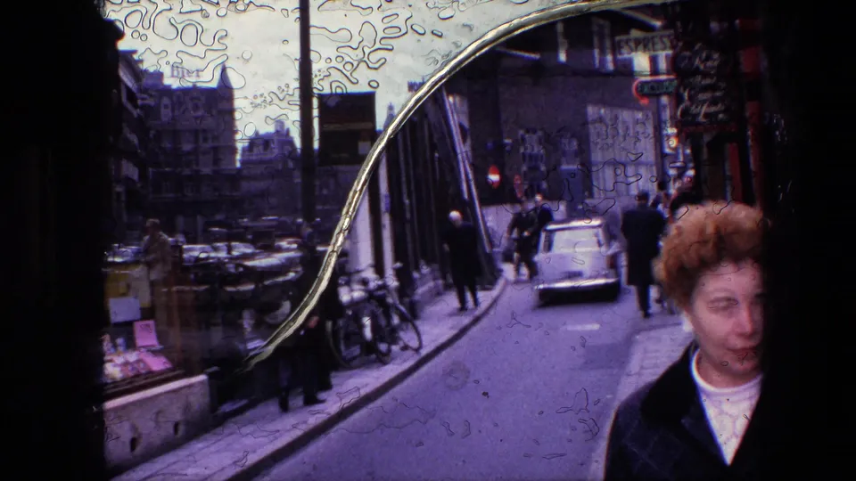 1967 Amsterdam street view with a curved reflective shop window, pedestrians, parked bicycles, and cars on a narrow road.