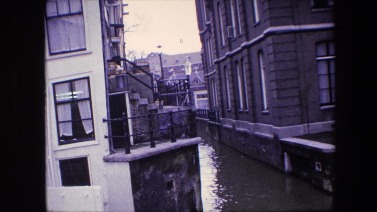 Amsterdam canal view from supplied 1967 metadata, with tall windows, black railings, exterior steps, and high water along the building edge.
