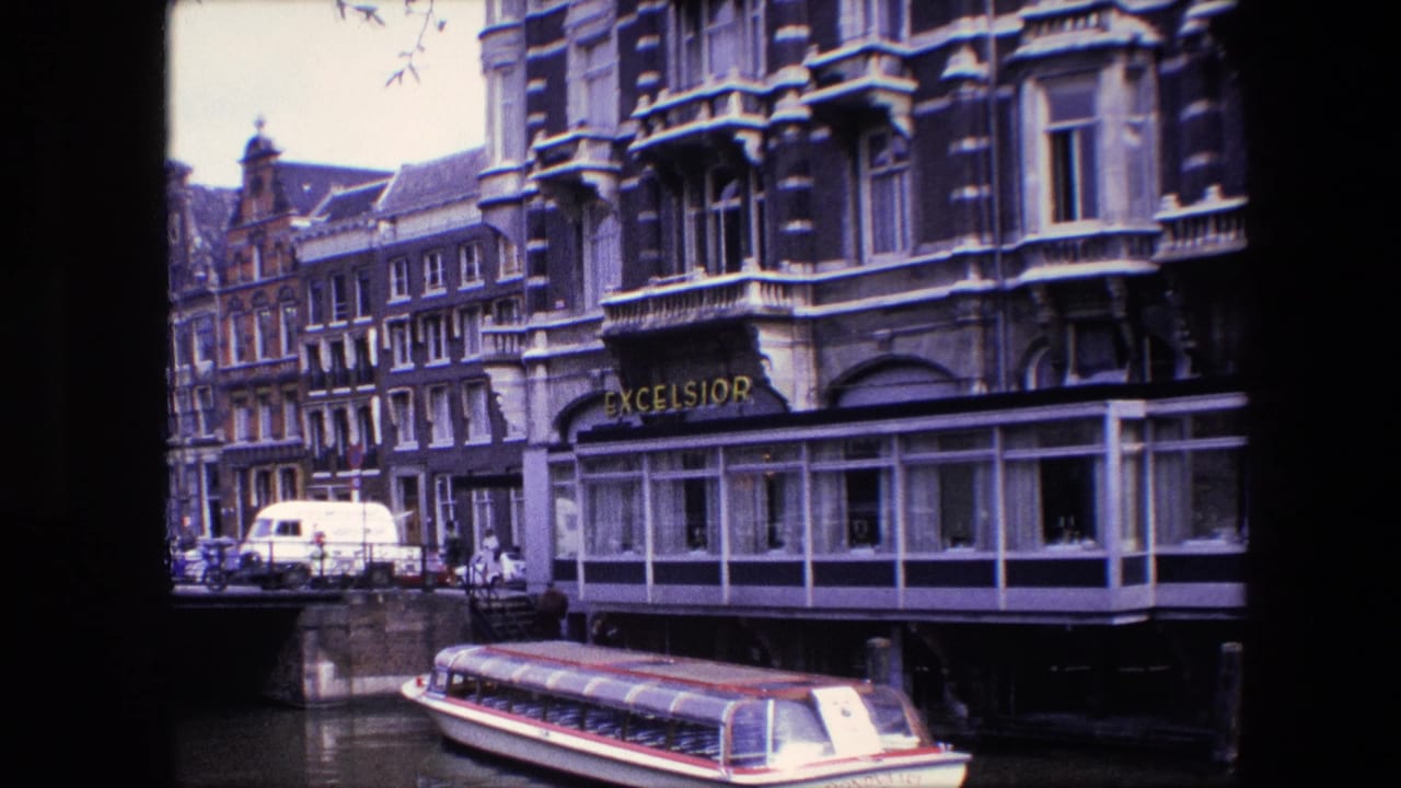 Tour boat and canal-side hotel facade with Excelsior signage.