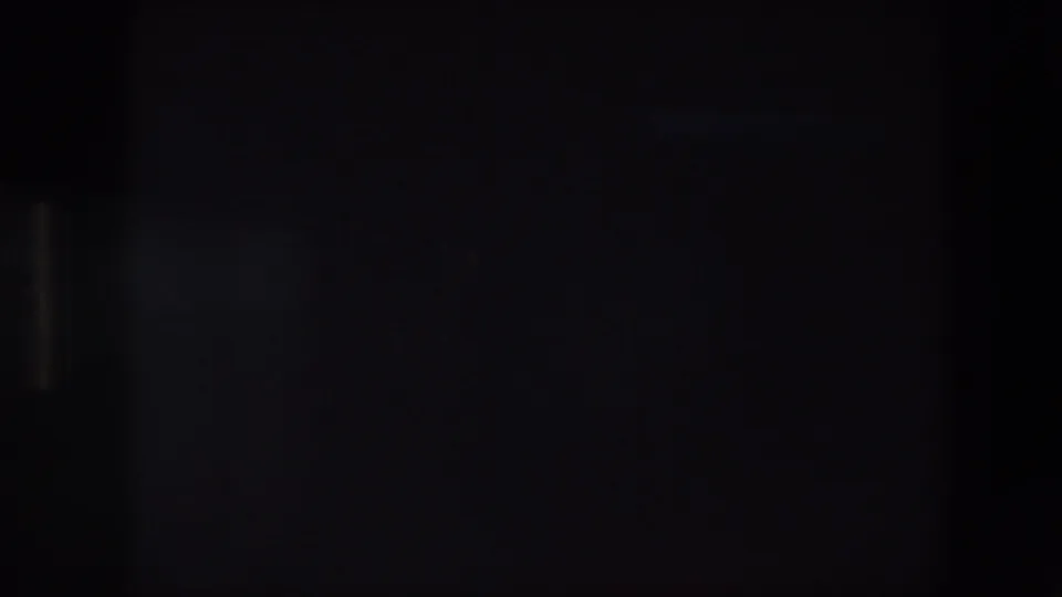 Very dark 8mm frame, likely an exposure or transition moment within the home-movie clip.