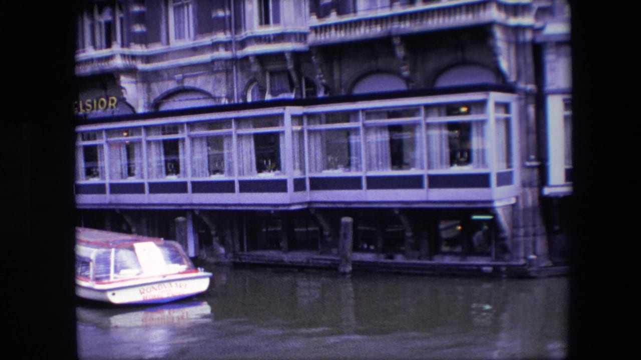 Closer 8mm view of the Excelsior restaurant terrace over the canal, with part of the Rondolet boat at the lower left edge.
