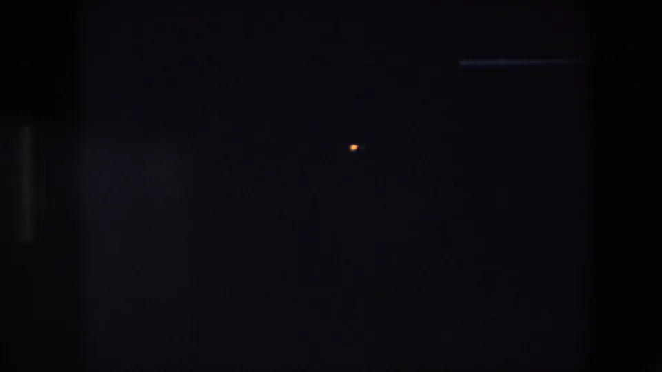 The opening 8mm frame is largely obscured by a dark foreground area, with only a small point of light and faint structural edges visible.