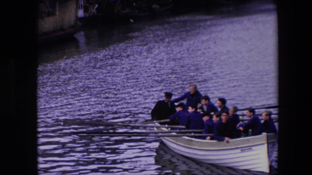 The final frame brings the rowing crew nearest to view, showing multiple adult men in the white boat with long oars and canal water filling most of the frame.