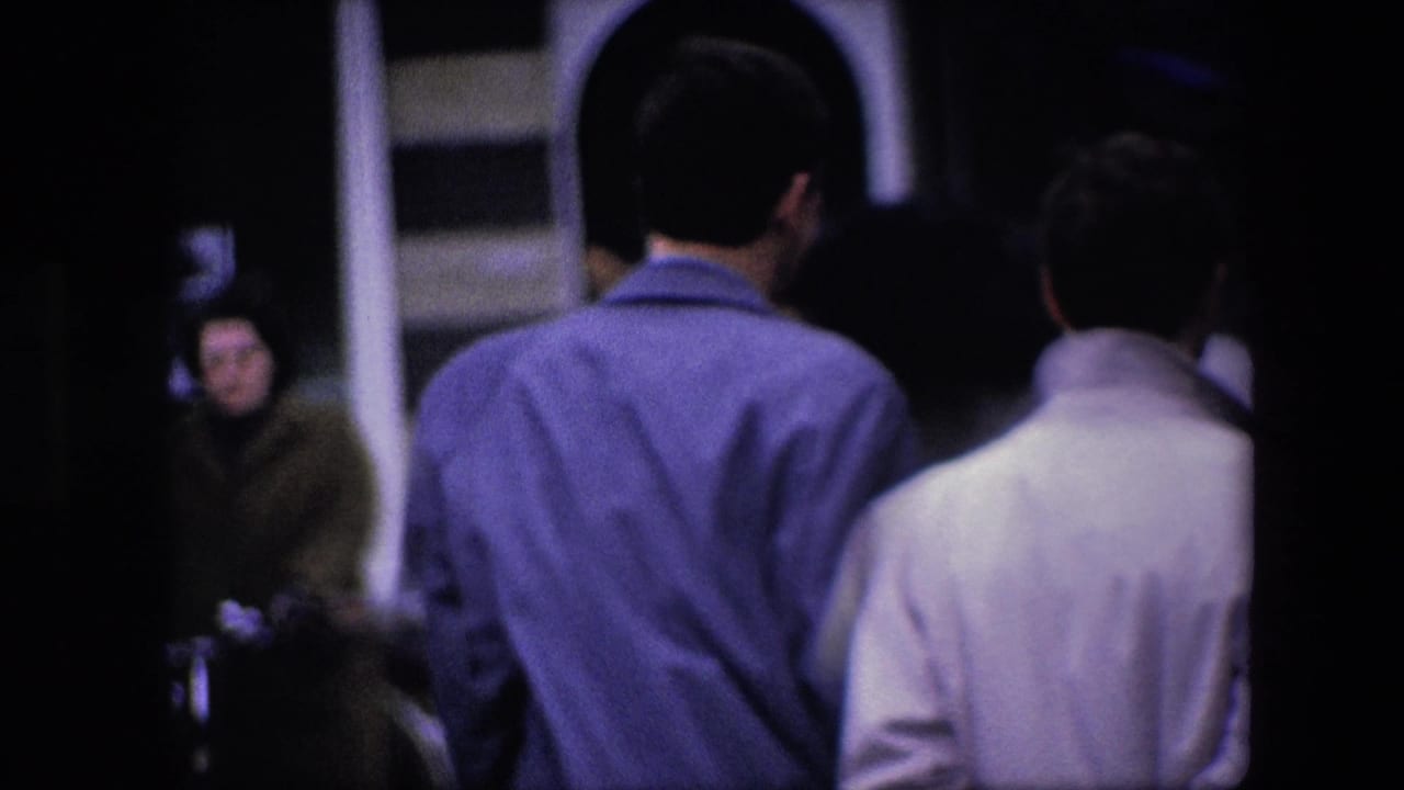 Two men seen from behind walking near a horse-drawn carriage and storefront entrance.