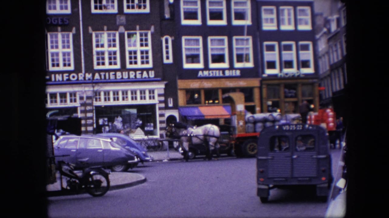 Street traffic continues past storefronts with a horse-drawn cart, cars, pedestrians, and a dark van in the foreground.