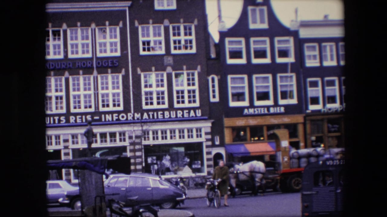 Dutch storefronts with a horse cart, parked cars, and a cyclist near the curb.