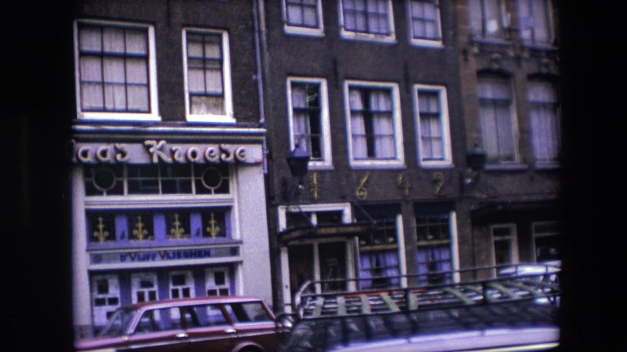 1967 Amsterdam street view showing narrow dark building facades, the Kroese storefront sign, parked cars, and pedestrians near street-level shops.