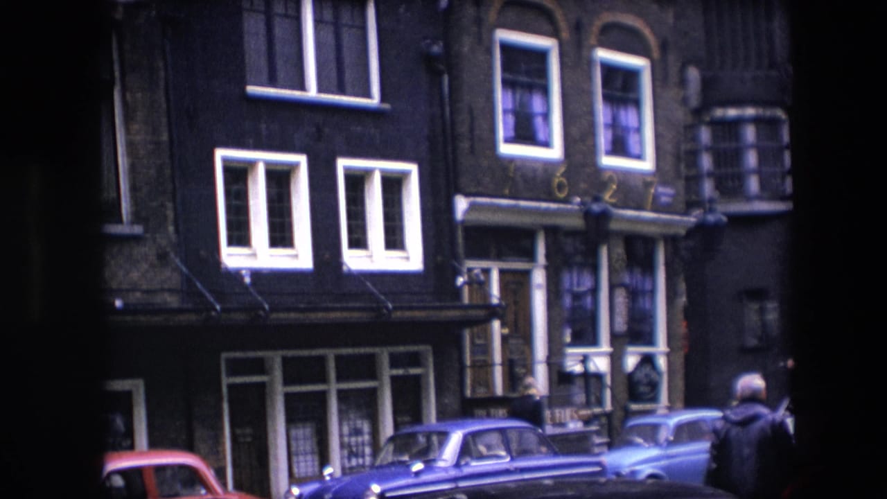 Dark brick street facade with parked cars and white-trimmed windows.