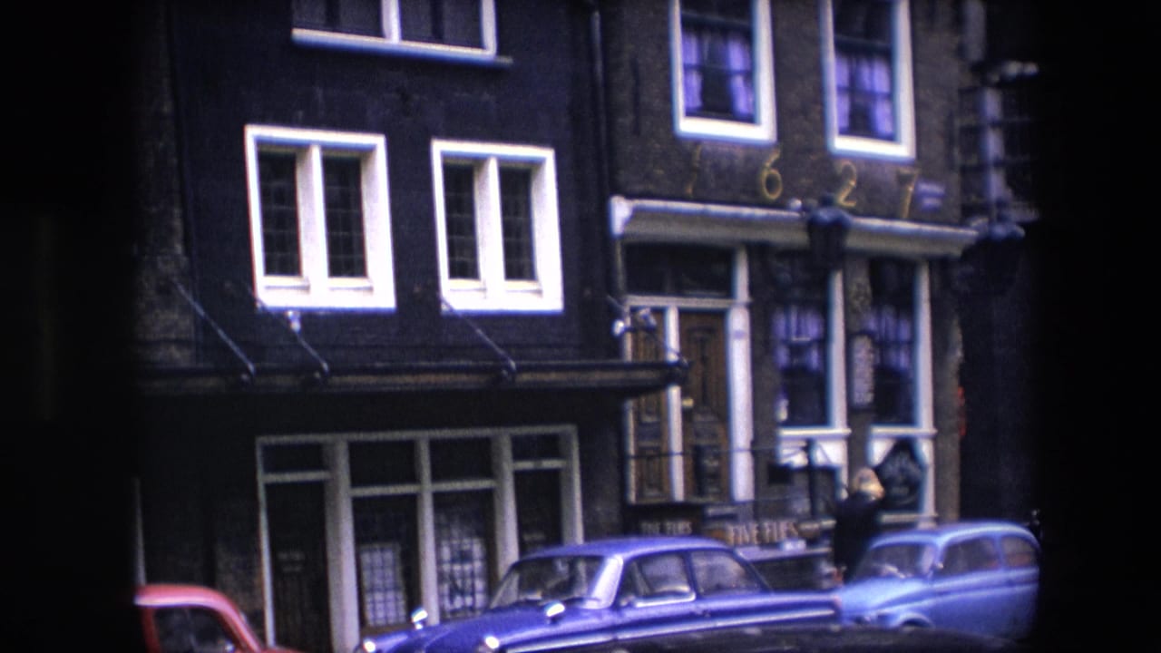 Brick building frontage with parked cars and a pedestrian near the doorway.
