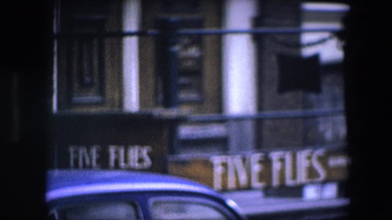 Storefront sign and building facade partially obscured by dark vertical frame edges.