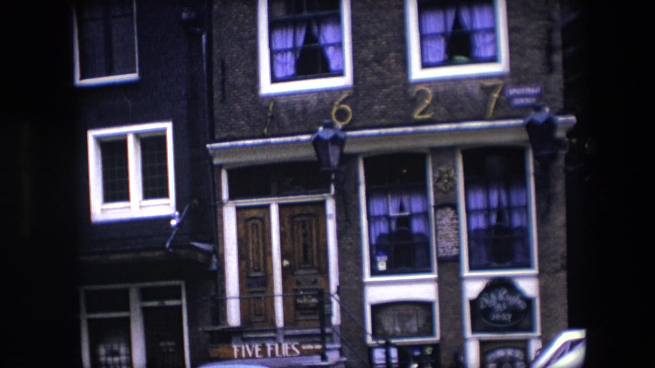 Closer street-facing view of the brick building with 1627 numerals, lamps, windows, and Five Flies signage.
