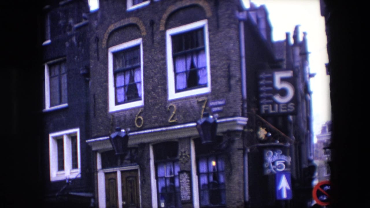 Townhouse corner with white-framed windows, address numbers, and 5 Flies signage.