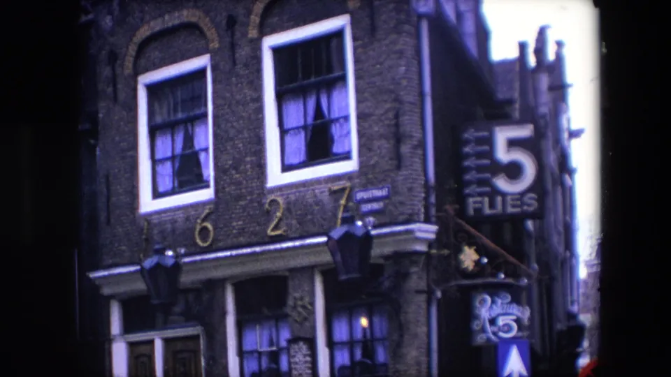 Closer 1967 Amsterdam view of the brick building facade, with address numerals above the doorway, curtained upper windows, and the 5 Flies sign on the right.