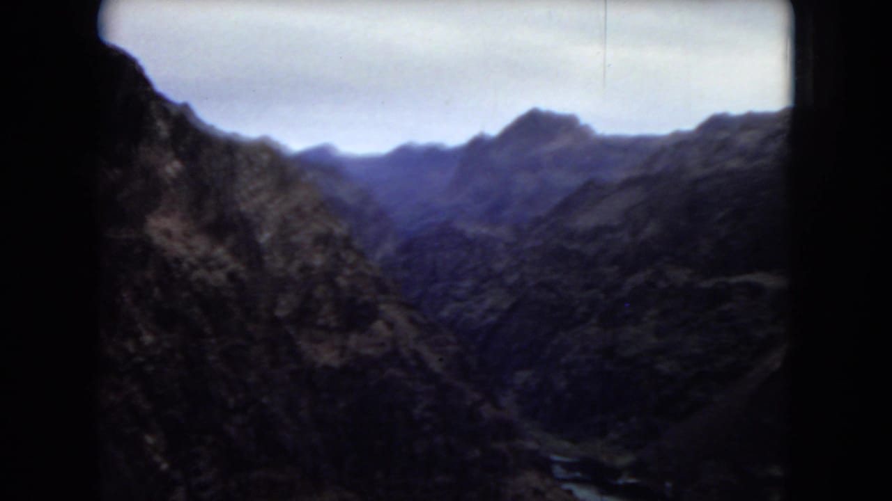 1967 8mm canyon landscape near the supplied Boulder Dam location, showing rugged mountains and a distant valley under a pale sky.