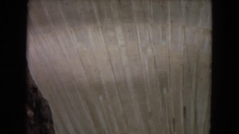 Close 1967 8mm view of unfinished beige concrete on a large dam structure, with vertical streaks, soft focus, and dark film gate borders.