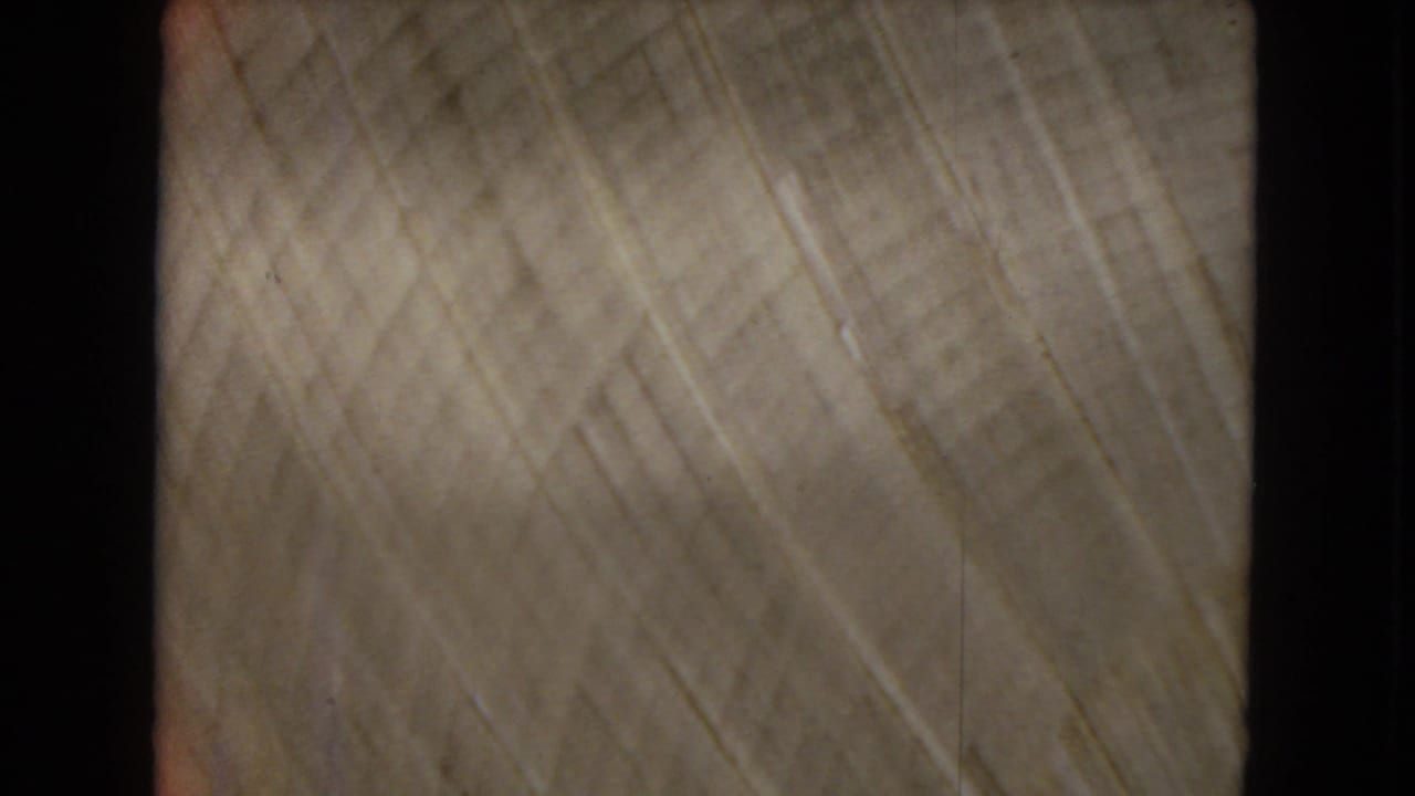 Soft blurred close view of pale textured film with diagonal streaks.