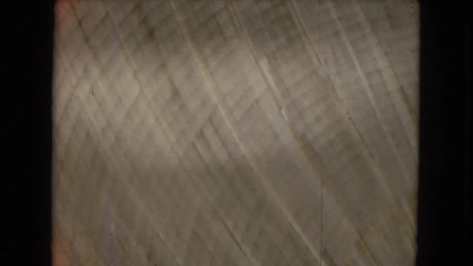 Blurred 8mm frame with pale textured streaking and no distinct landscape details visible.