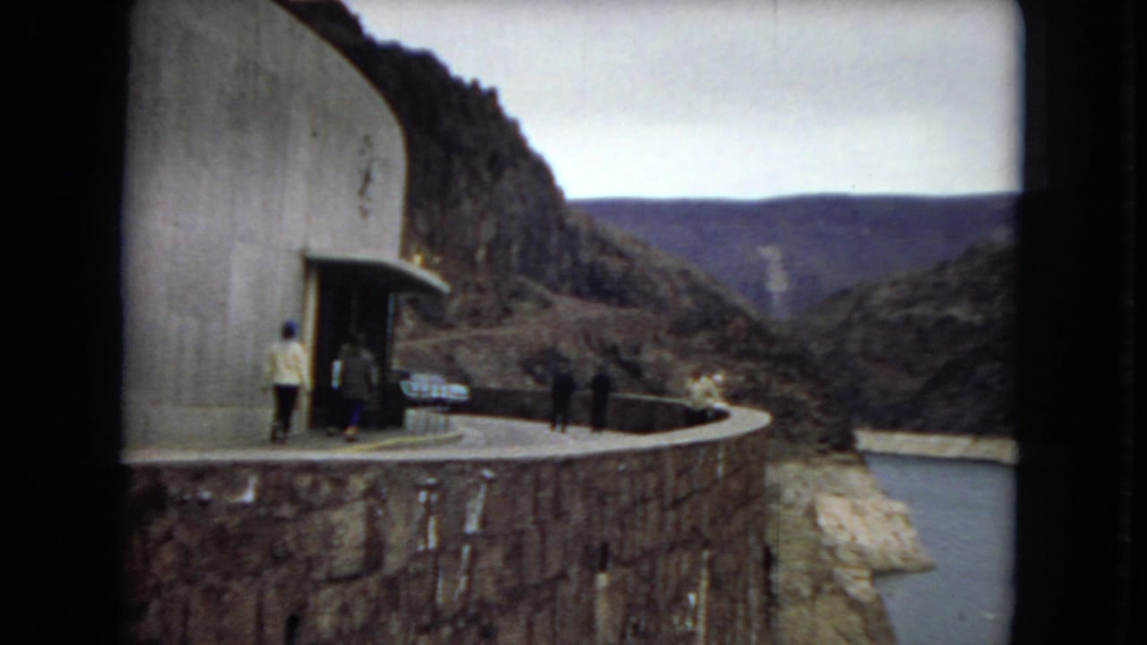 1967 Arizona 8mm footage shows visitors on a curved dam-side walkway with canyon walls and reservoir water beyond.