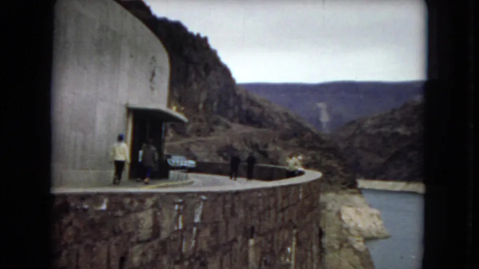 1967 Arizona 8mm footage shows visitors on a curved dam-side walkway with canyon walls and reservoir water beyond.