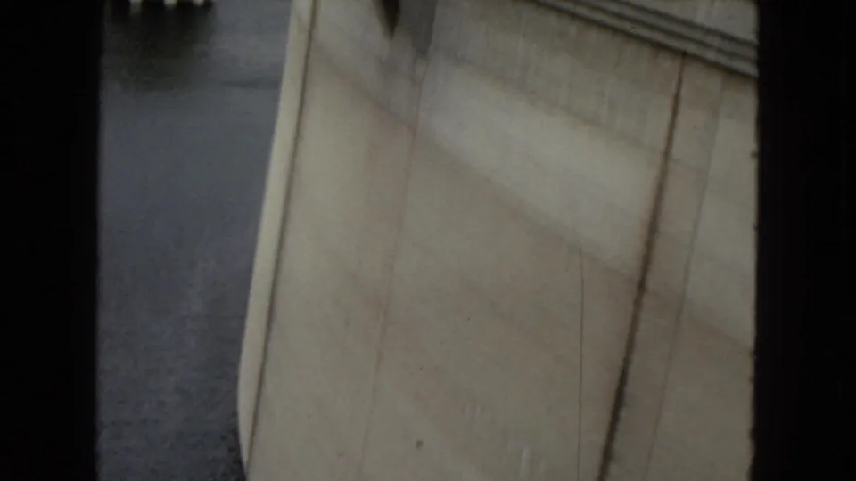 Close 1967 home-movie view of Hoover Dam concrete and adjacent water, framed tightly with soft focus and black 8mm borders.