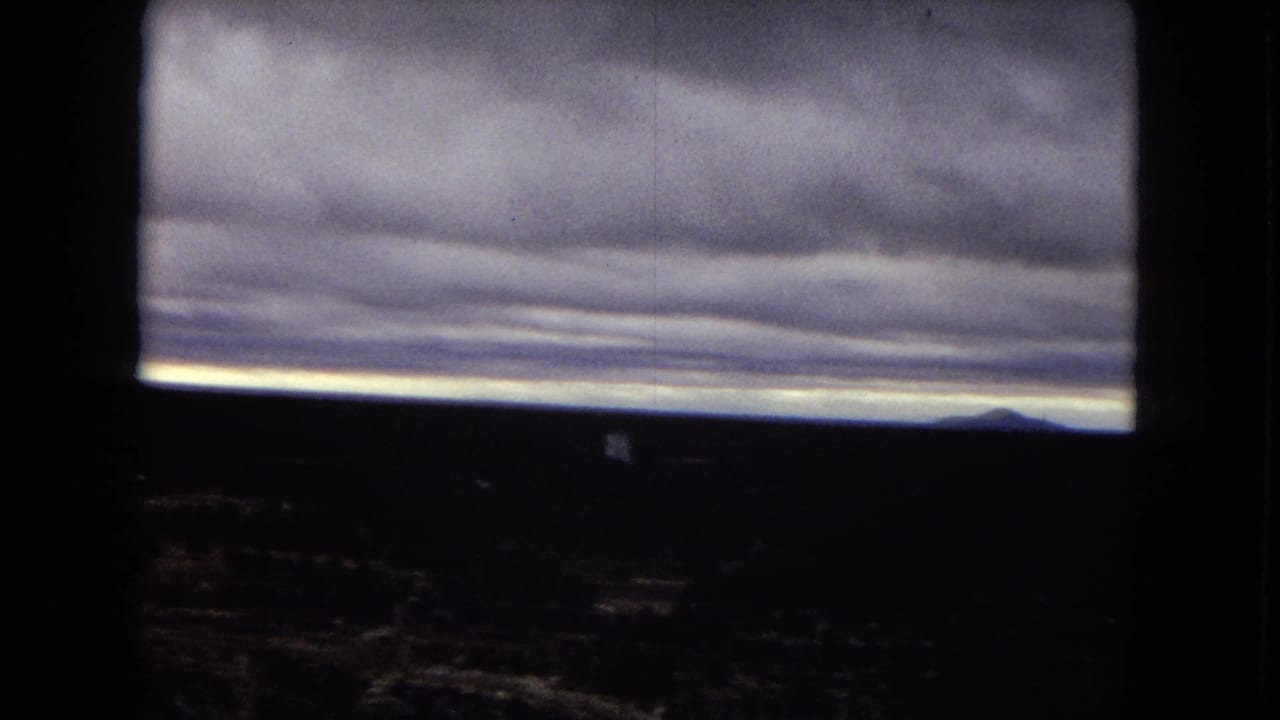 Overcast sky and distant canyon rim seen through dark 8mm frame edges.