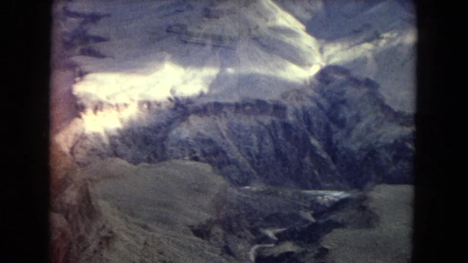 1967 8mm Arizona travel footage appears to show snow-dusted canyon and mountain ridges under clouded light, with dark frame edges and faded color.