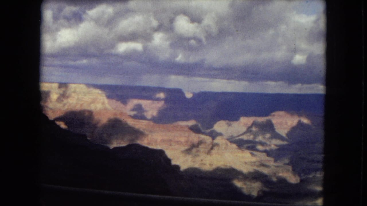 Grand Canyon view with layered cliffs under a cloudy sky.