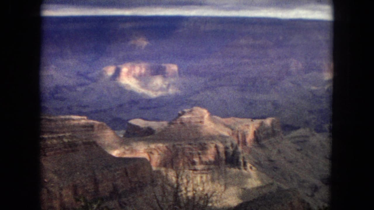 Grand Canyon cliffs and mesas seen across a shadowed basin.